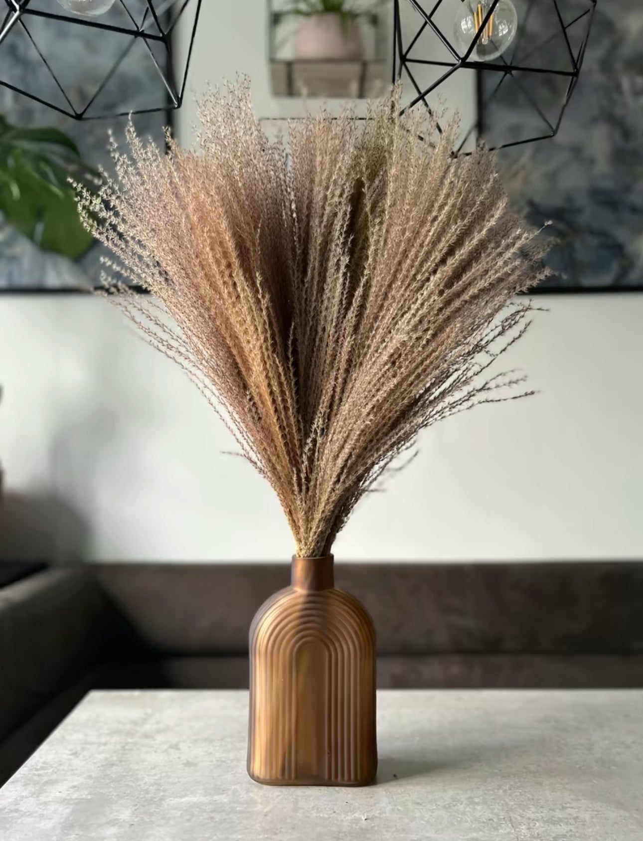 Natural fluffy dried stipa displayed in a brown vase