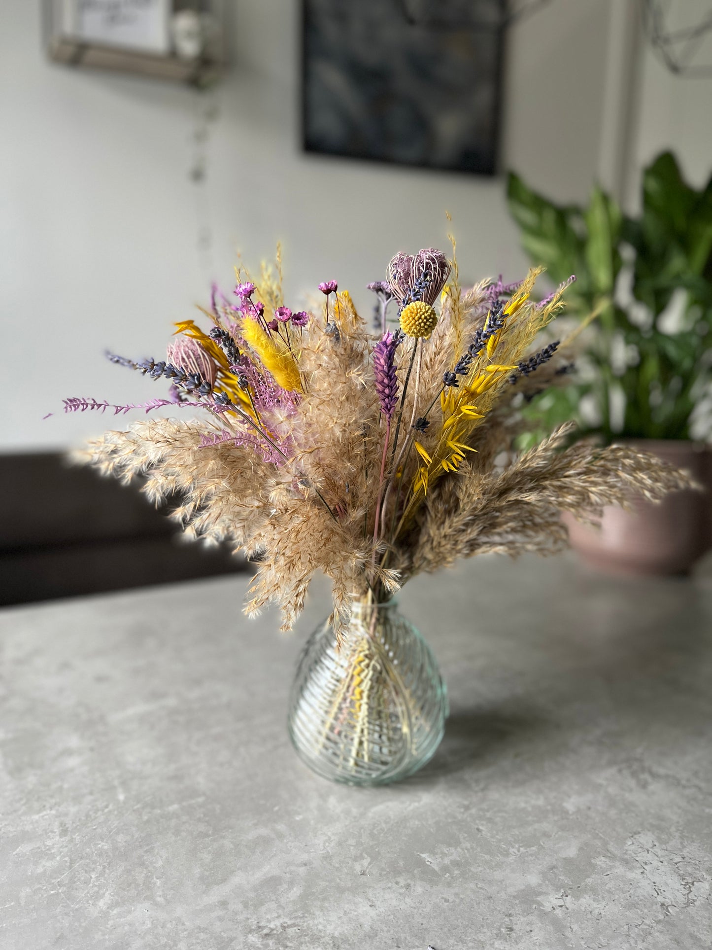 Clear glass leaf vase displayed on a table with natural dried flowers