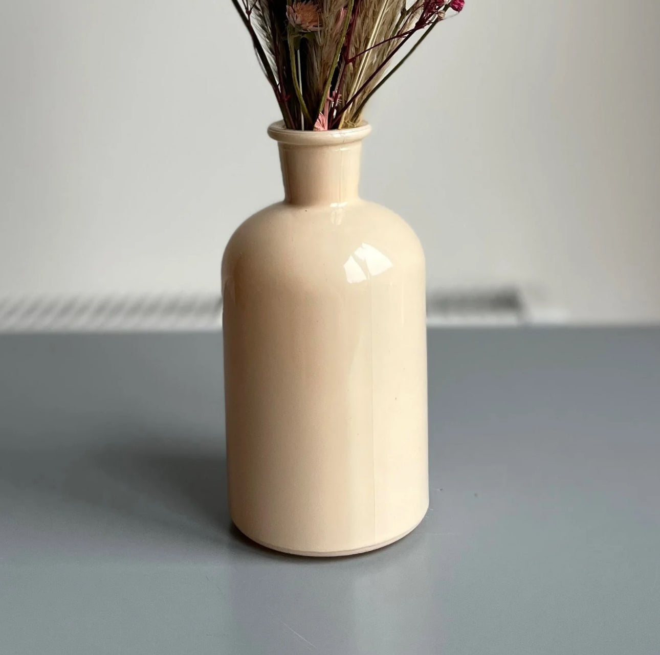 Cream bottle vase displayed on a table 