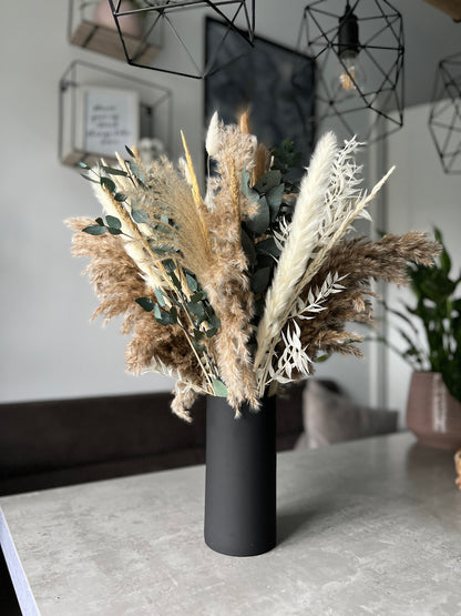 Matt black cylinder vase displayed on a table with dried flowers