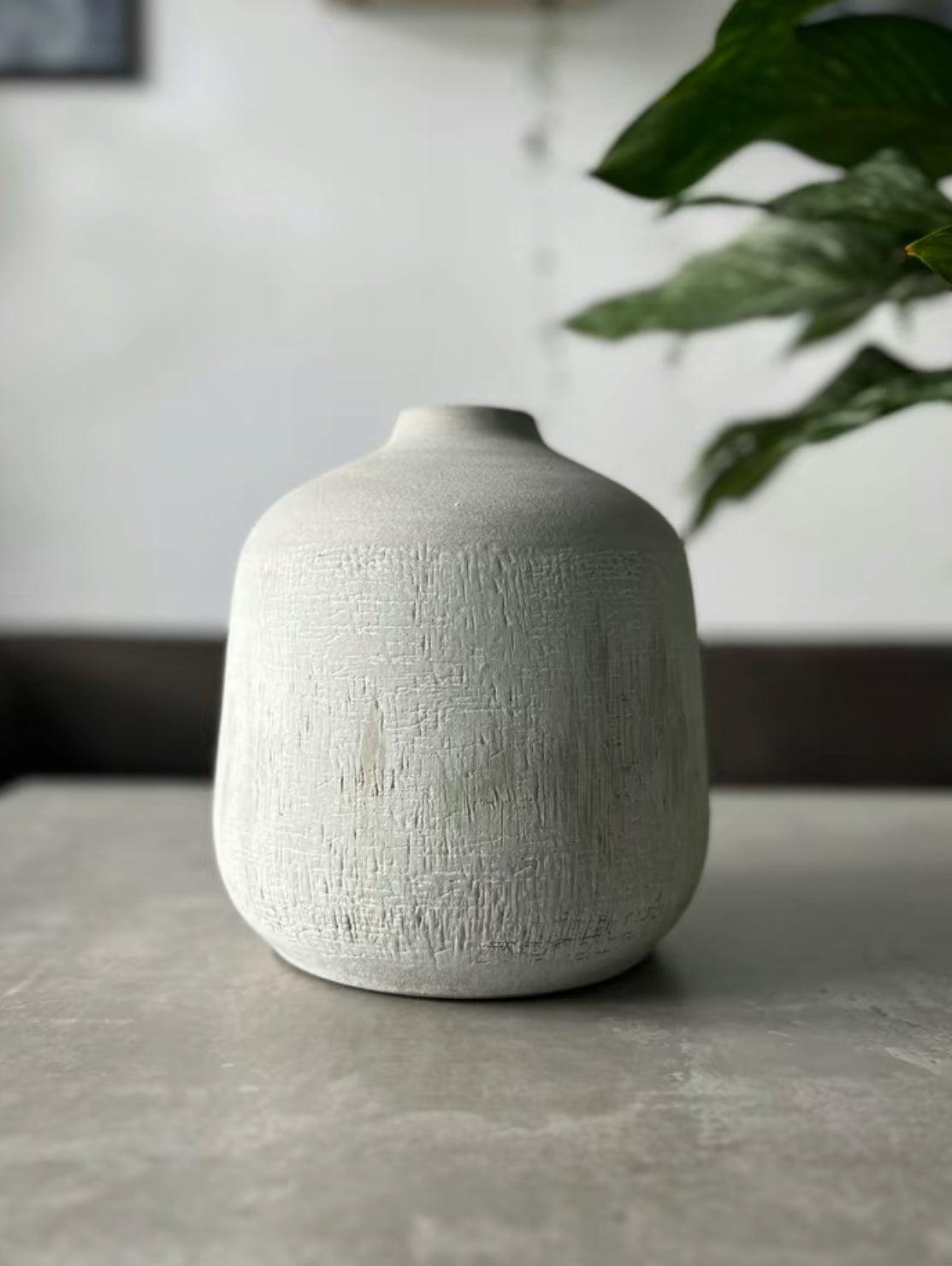 Terracotta stone colour vase in the shade dark grey being displayed on a table