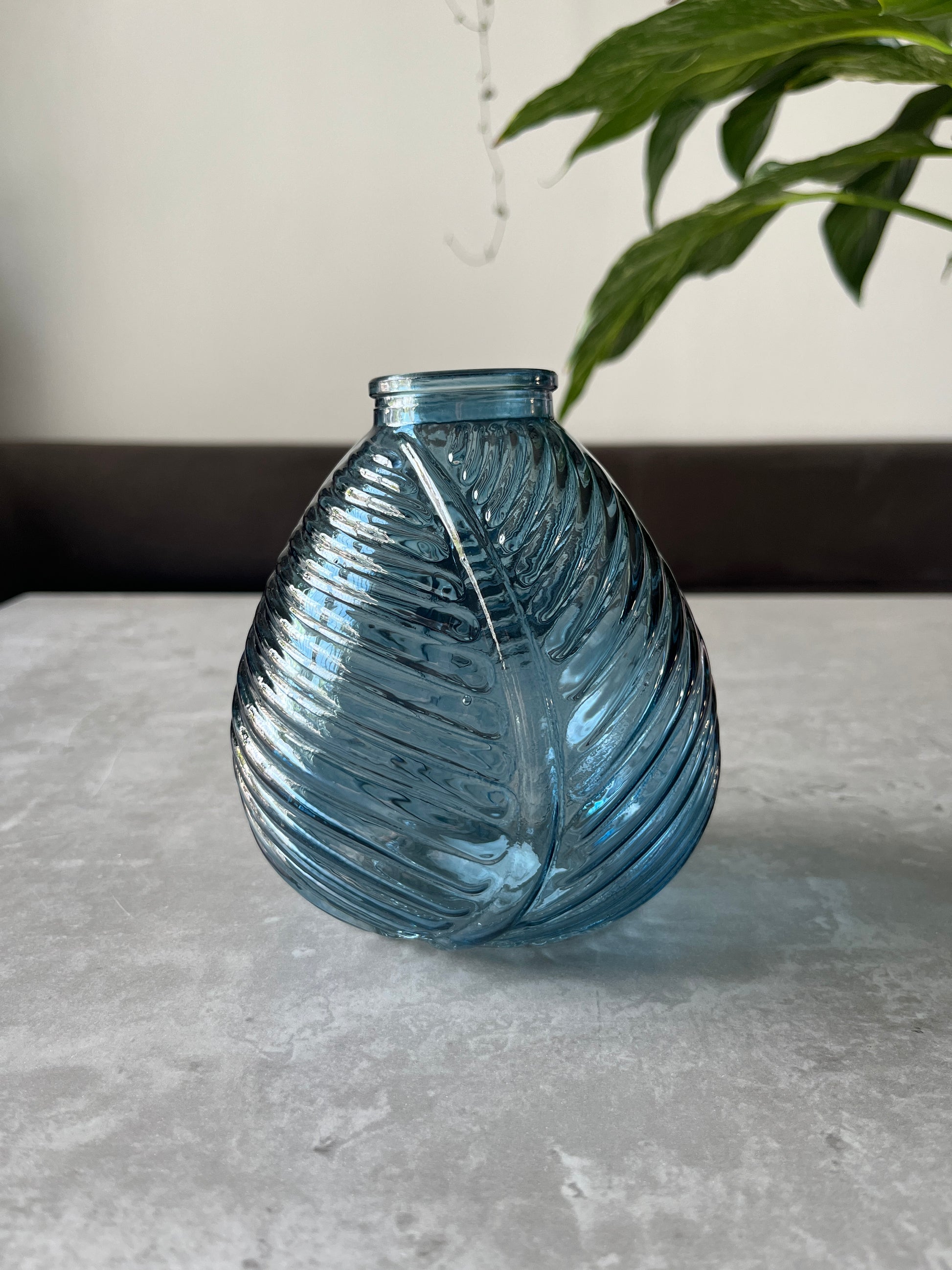 Blue glass leaf vase displayed on a table