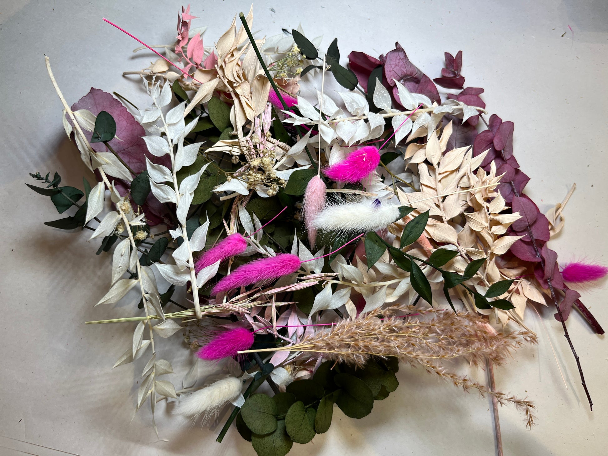 Multicoloured dried flowers on white tissue paper